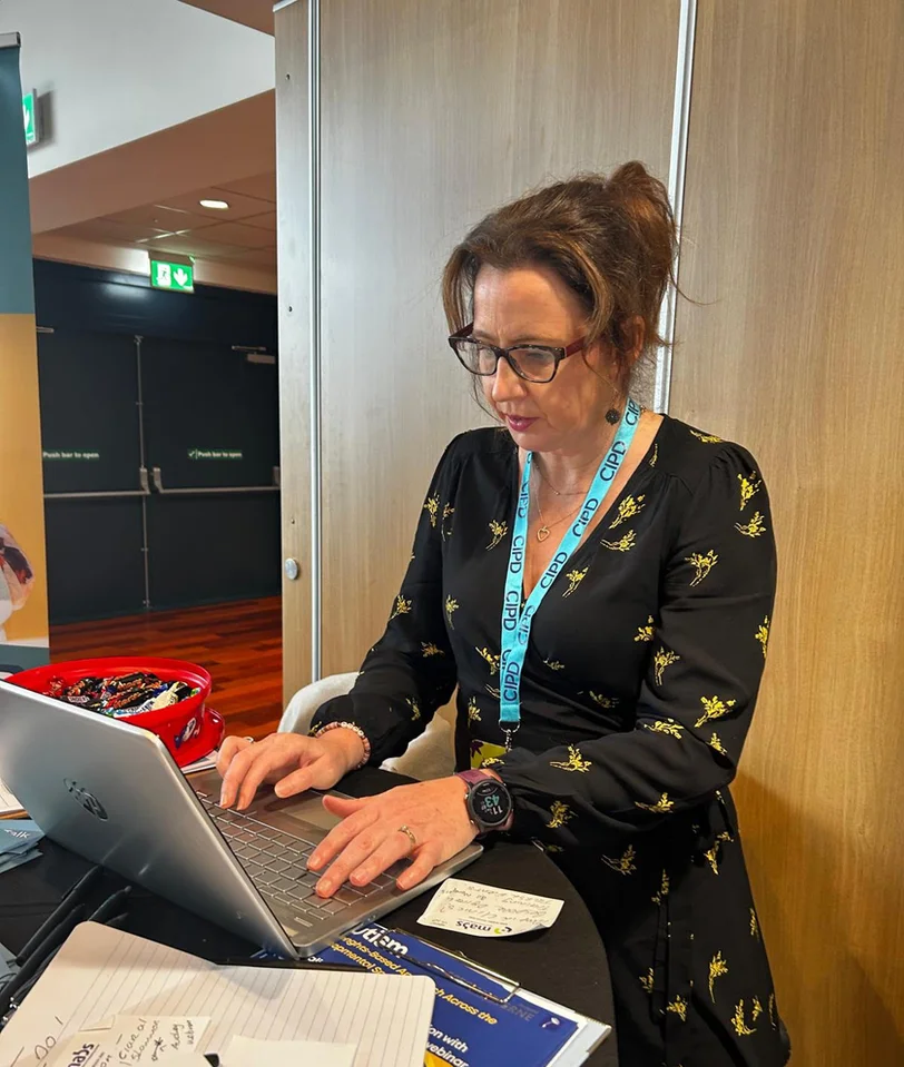 Sharon working at a laptop at a ParenTalk event